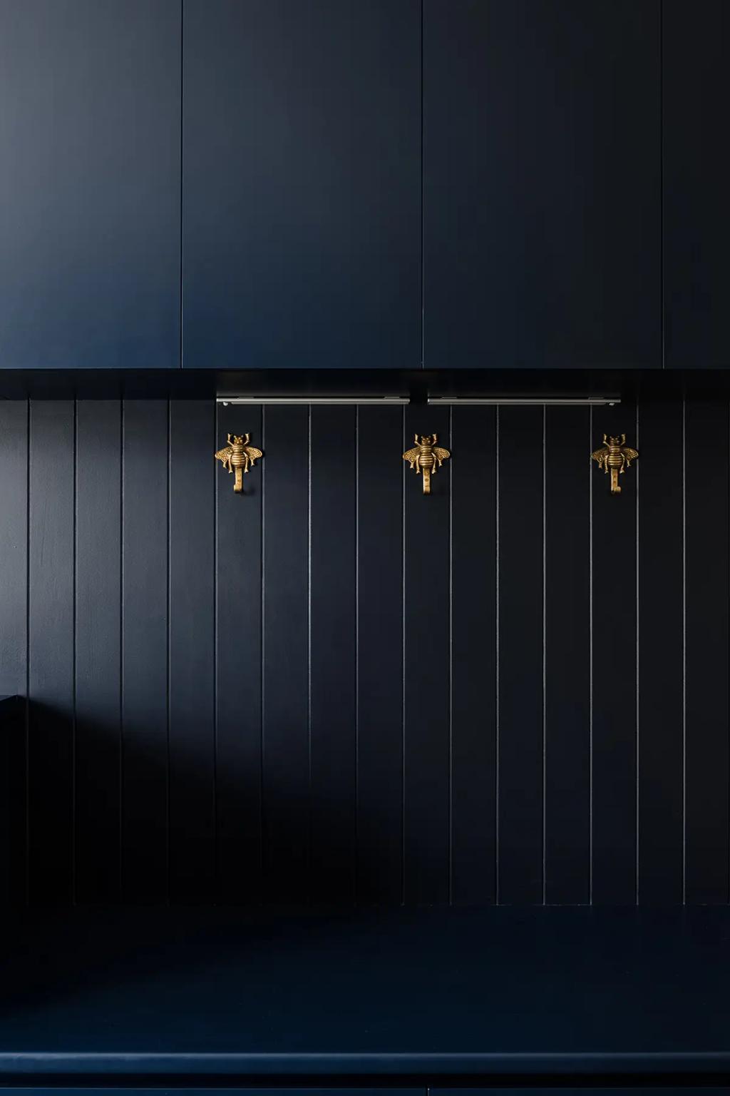 Cheltenham (Dark navy wall with brass animal hooks and panels)