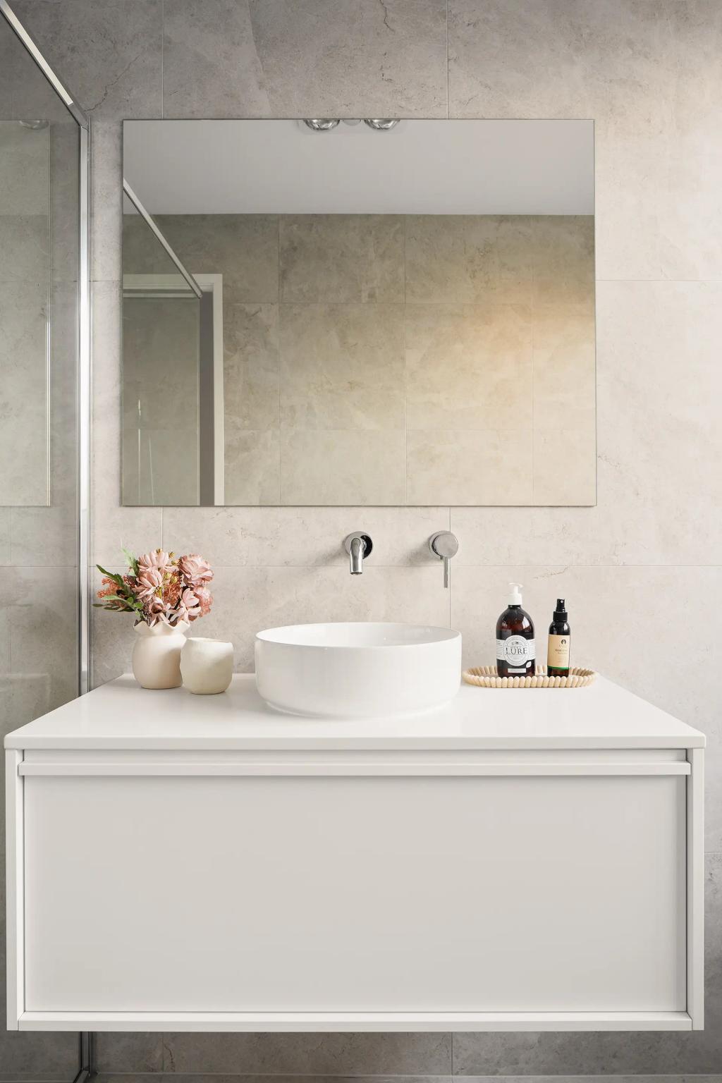 Project Ward (Modern bathroom with a round sink, large mirror, flowers in a vase, and toiletries on the counter)