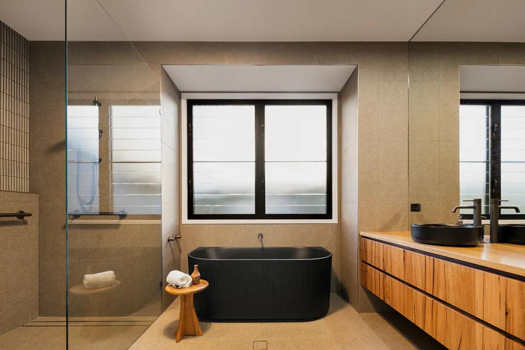 Project Treevue (A modern bathroom with a large window and a black freestanding bathtub)