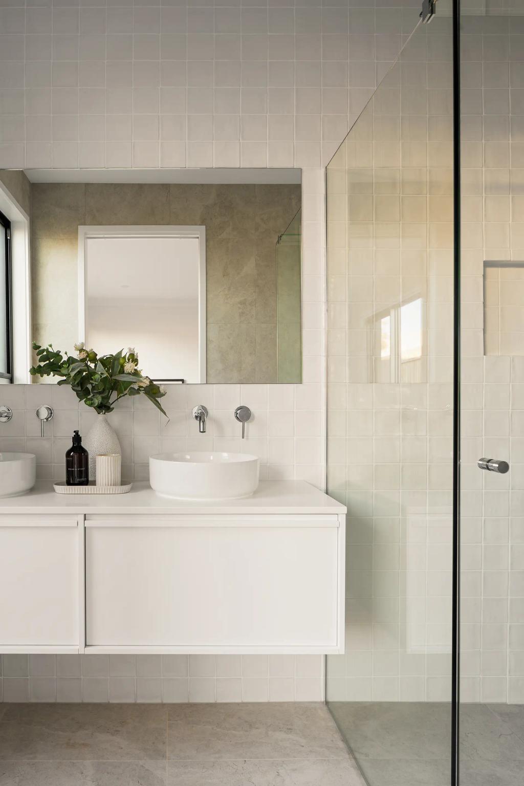 Project Ward (Modern bathroom with a glass shower, white vanity, round sink, and large mirror, decorated with plants)
