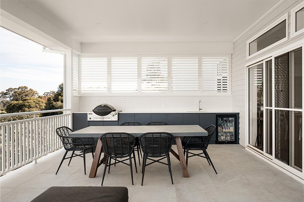 Six black rattan-style chairs around the table