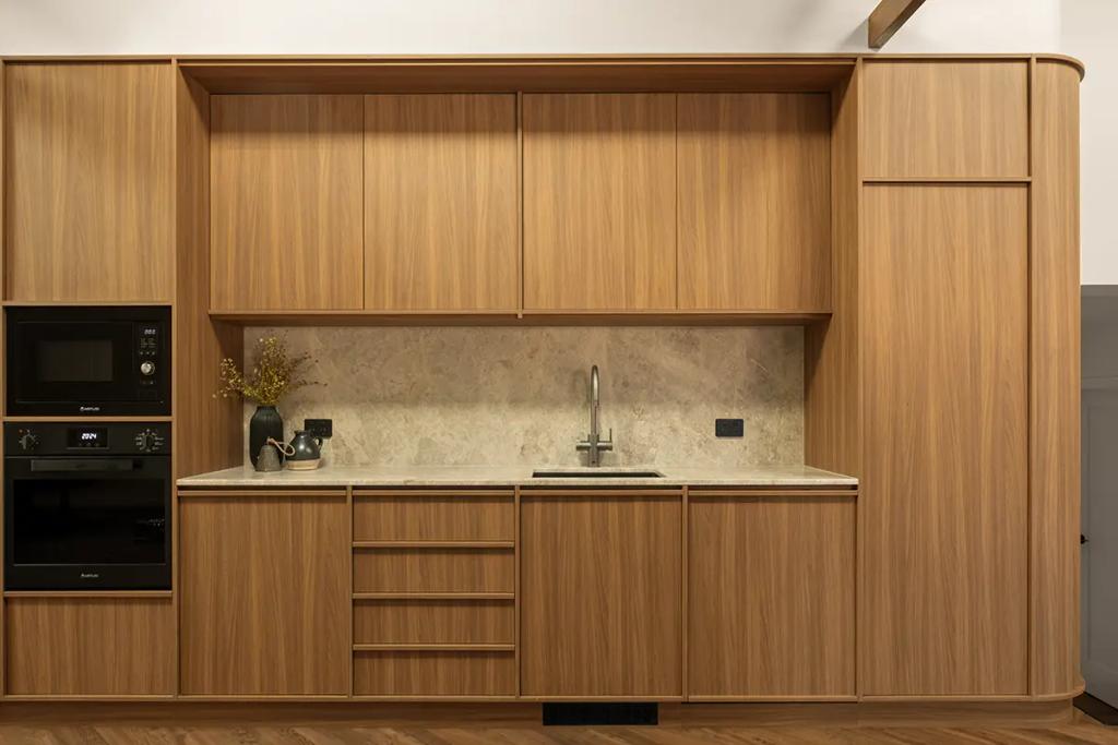 Built-in kitchenette with wood panels and marble top