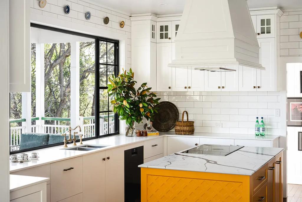 Project Coral Sea (Modern kitchen with white cabinets, large window, yellow island, marble countertop, and green plant)