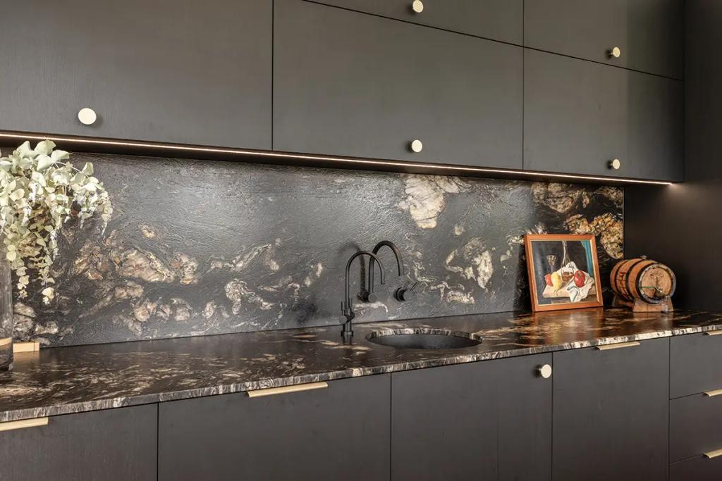 Hodgsonvale House Renovation (A sleek bar area with dark cabinets, a black sink, and a dramatic granite backsplash.)
