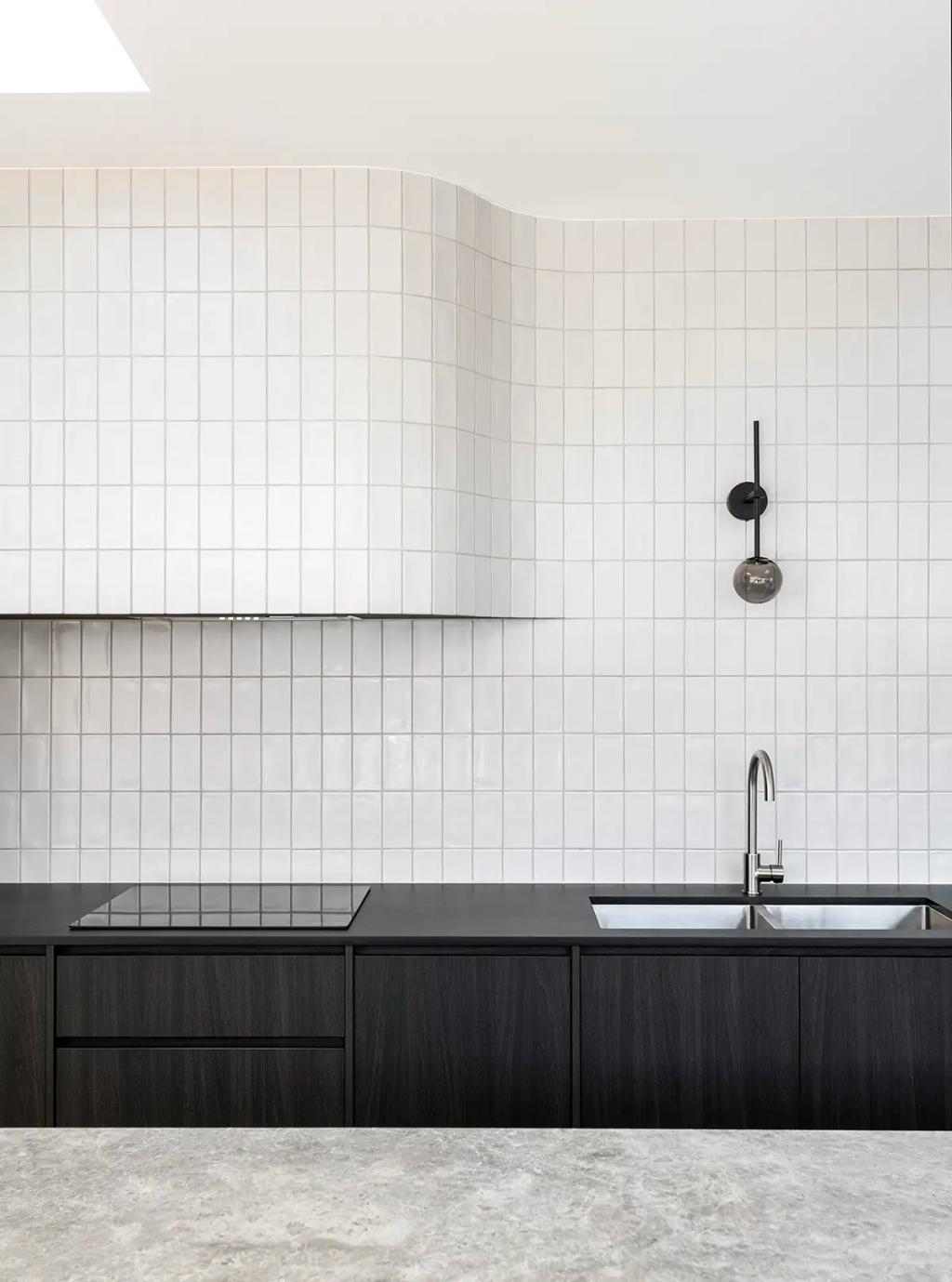 Project Ward 2.0 (Modern kitchen with white square tile backsplash, curved hood, black cabinetry, and a sleek chrome faucet)
