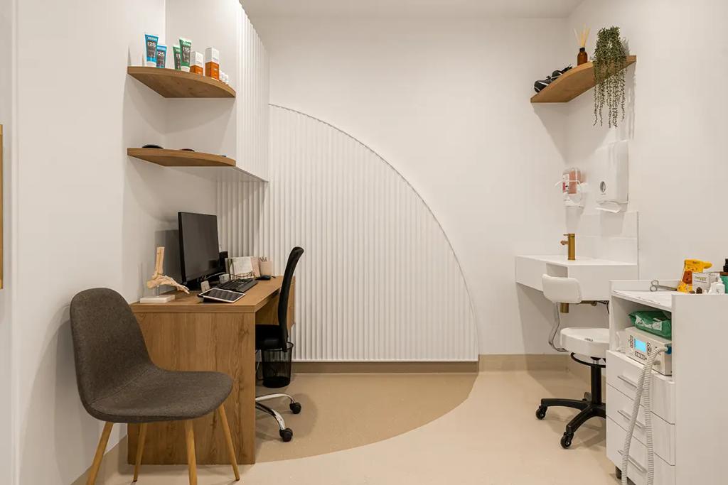 Lavish Constructions - Sole Podiatry (Podiatry exam room with desk, sink, and wall shelves.)