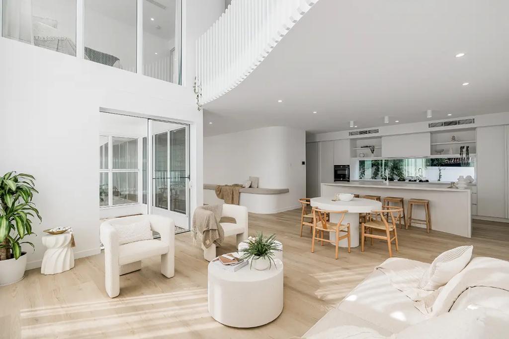 Project Vuse (A modern, minimalist open-plan living space with white walls, light wooden floors, high ceilings, and large windows)
