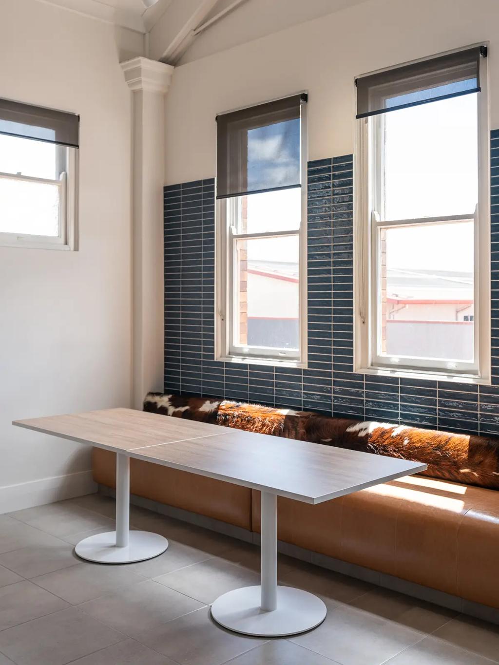 Downlands College Toowoomba Refurbishment (Minimalist meeting area with a long wood table, tan bench seating, and large windows with blinds.)