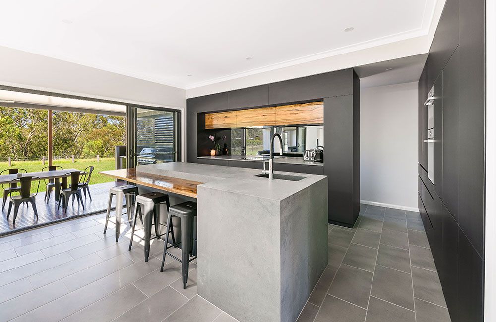 Project Tremorne (Concrete-look island with timber breakfast bar, dark cabinetry and open patio doors)