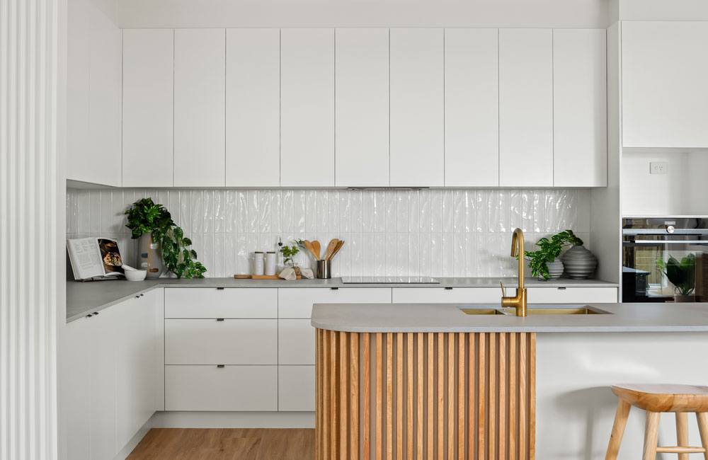 Project Drummond (White handleless kitchen with curved timber-slat island, grey benchtops and gold tap)