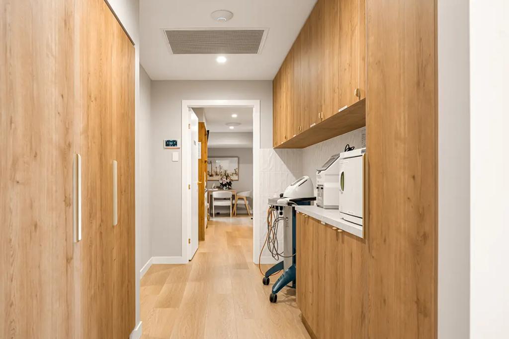 Lavish Constructions - Sole Podiatry (Clinic corridor with wood cabinets and equipment.)