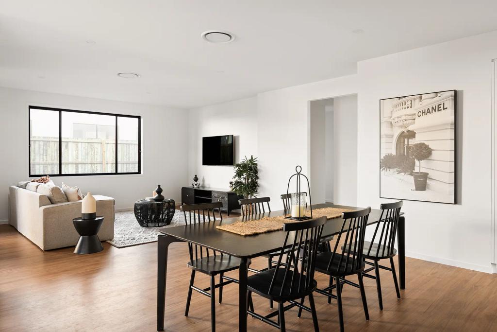 Project Ward (Open living and dining area with black chairs, a beige sofa, a Chanel print, and a large window)