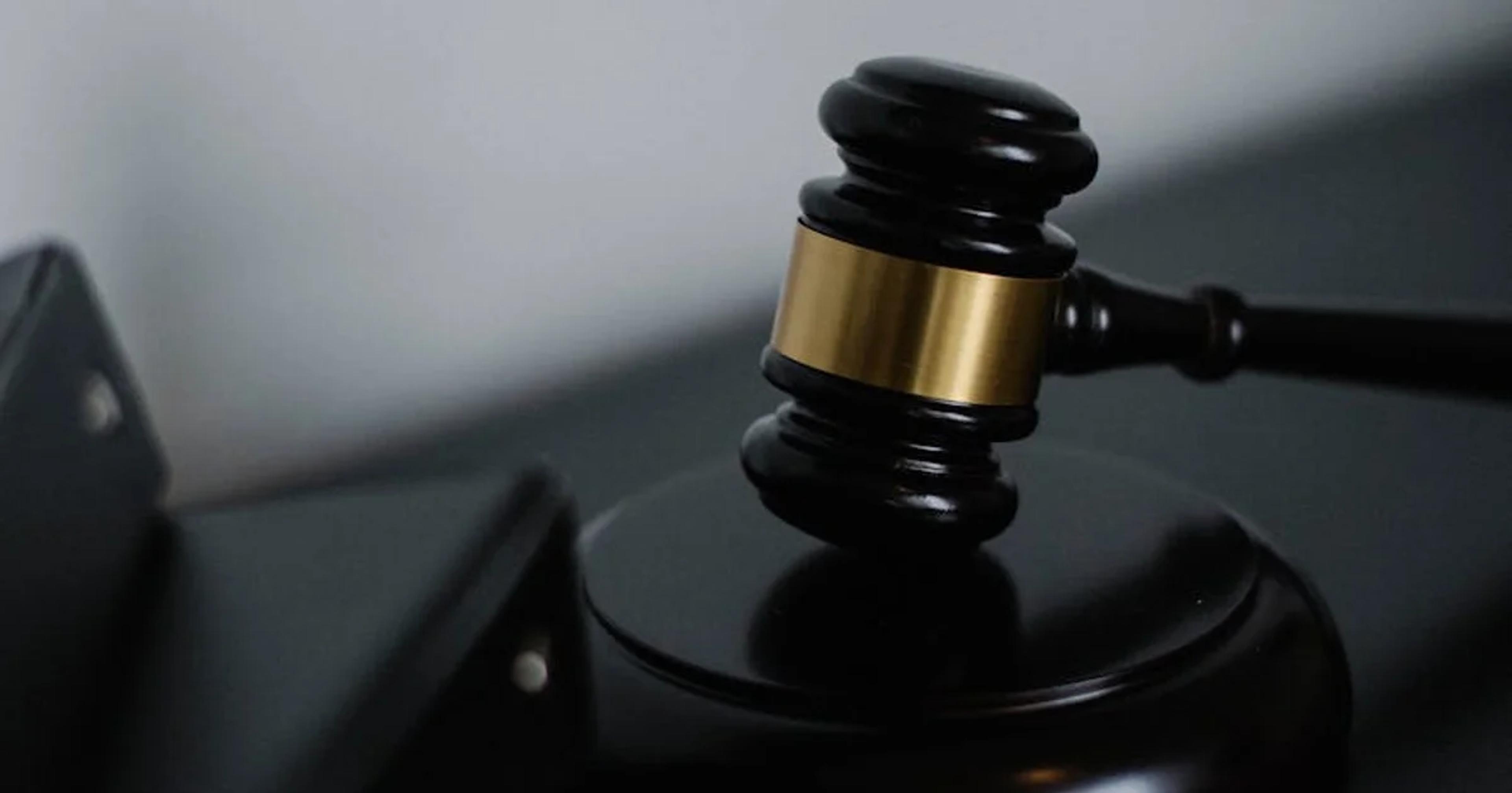 A high-tech courtroom setting with judges and lawyers examining AI-driven evidence screens.