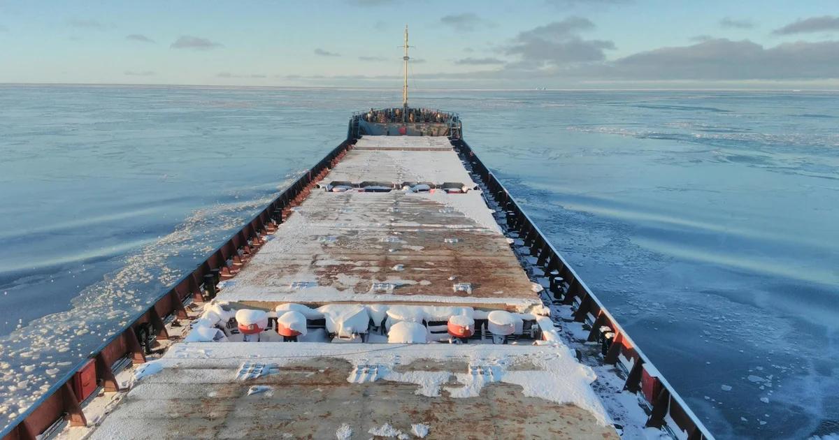 An autonomous cargo ship navigating stormy waters with digital overlays showing navigation security paths.