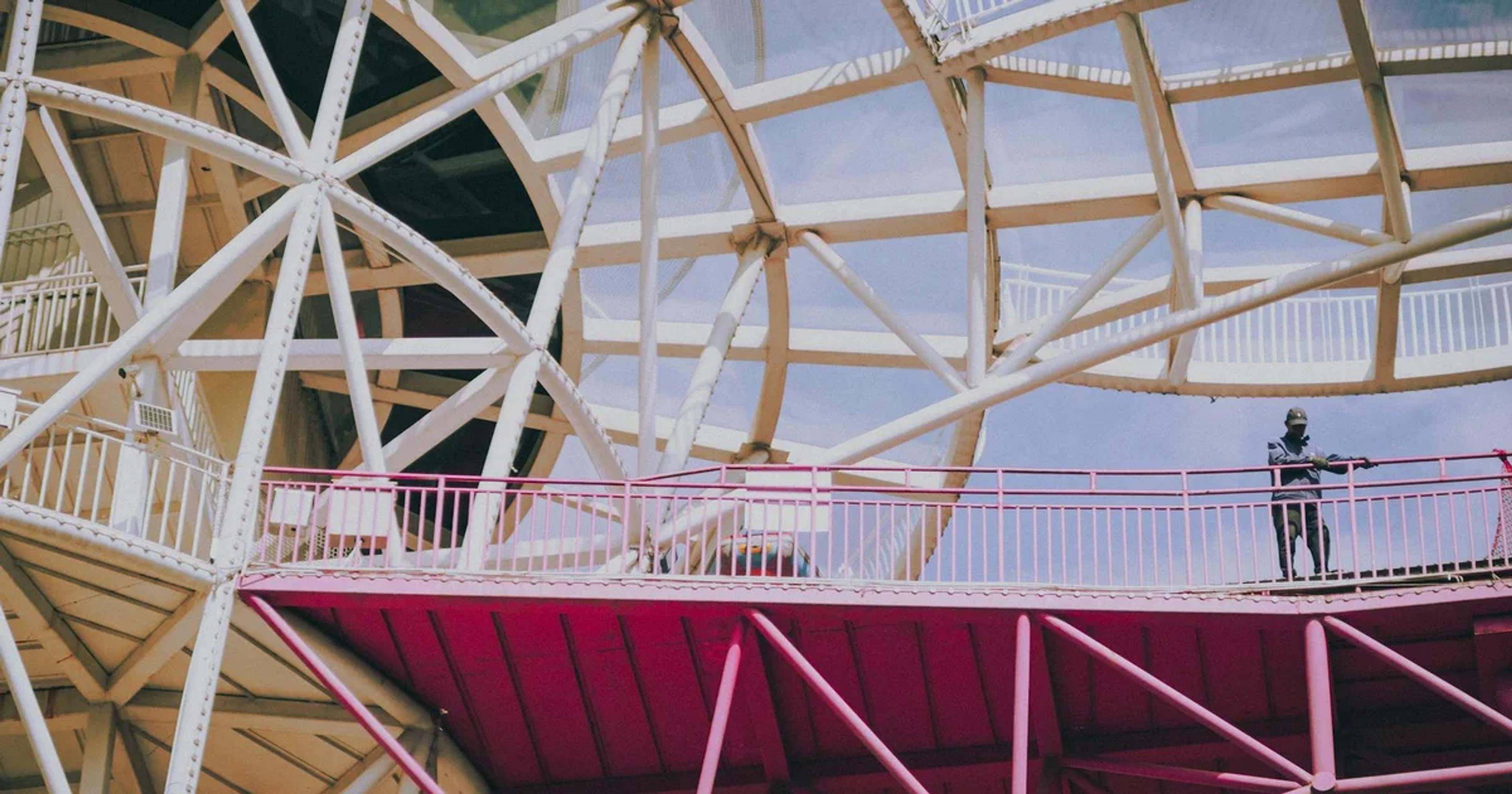 Human standing alone in a data center surrounded by glowing AI interfaces, symbolizing over-reliance and human vulnerability.
