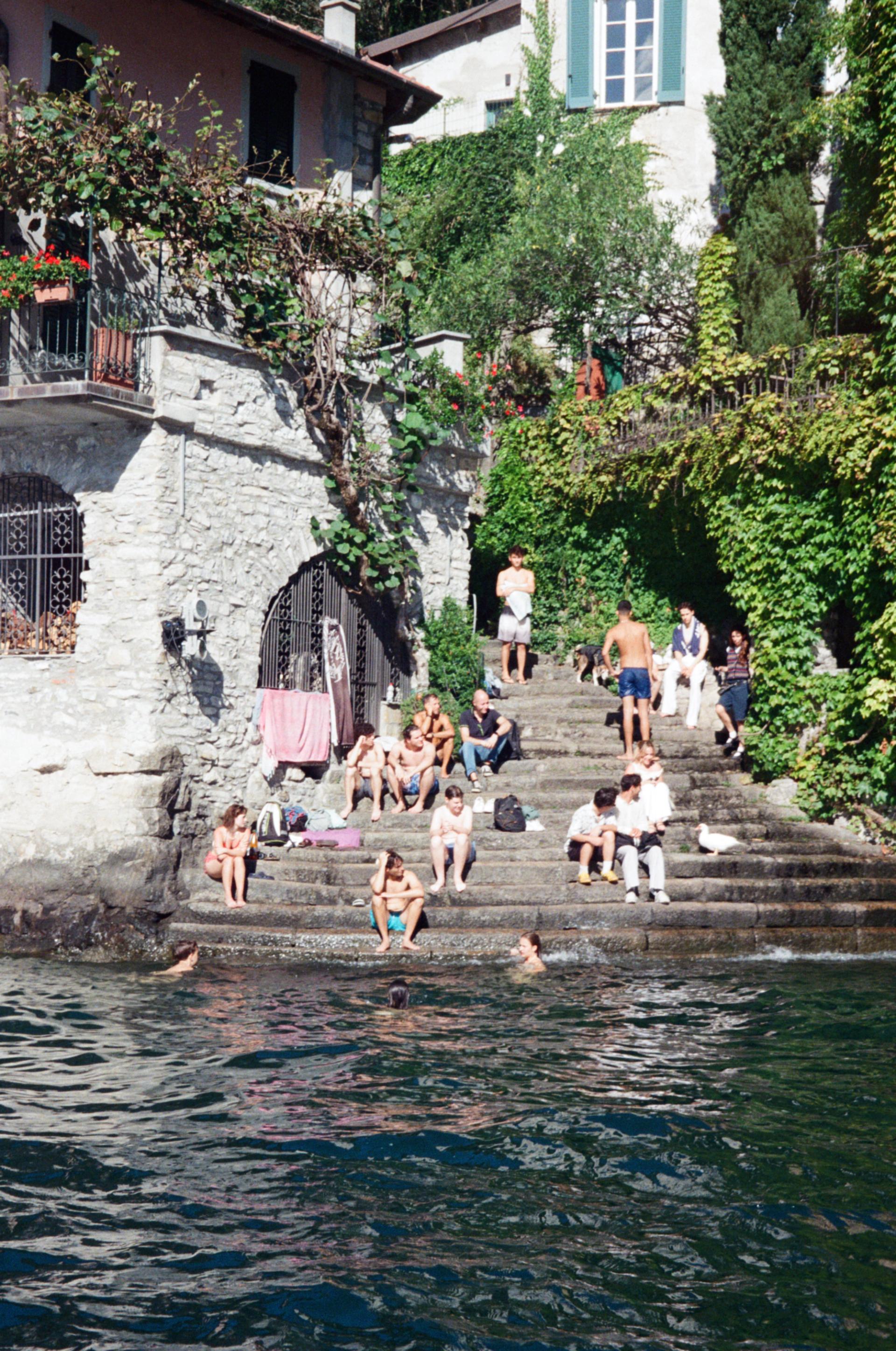 Swimmers waiting on the steps near the town of Lecco.