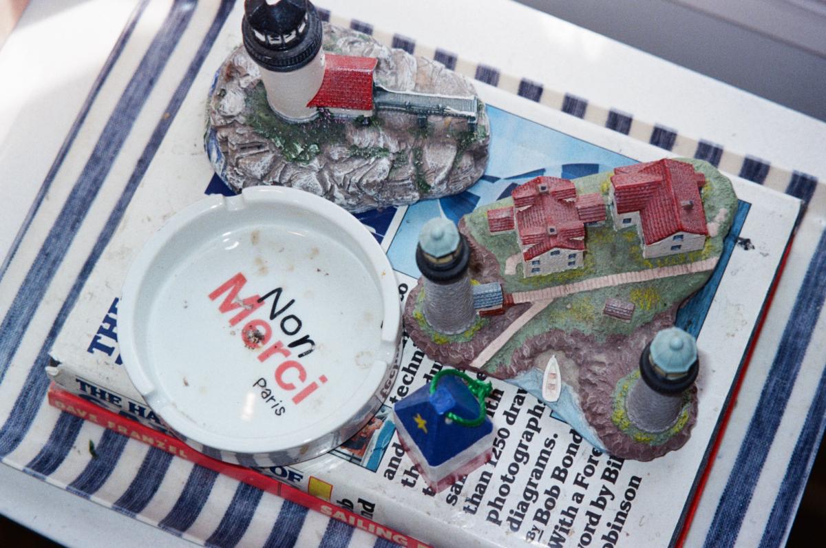 Ash tray and lighthouse figurines on striped tray.