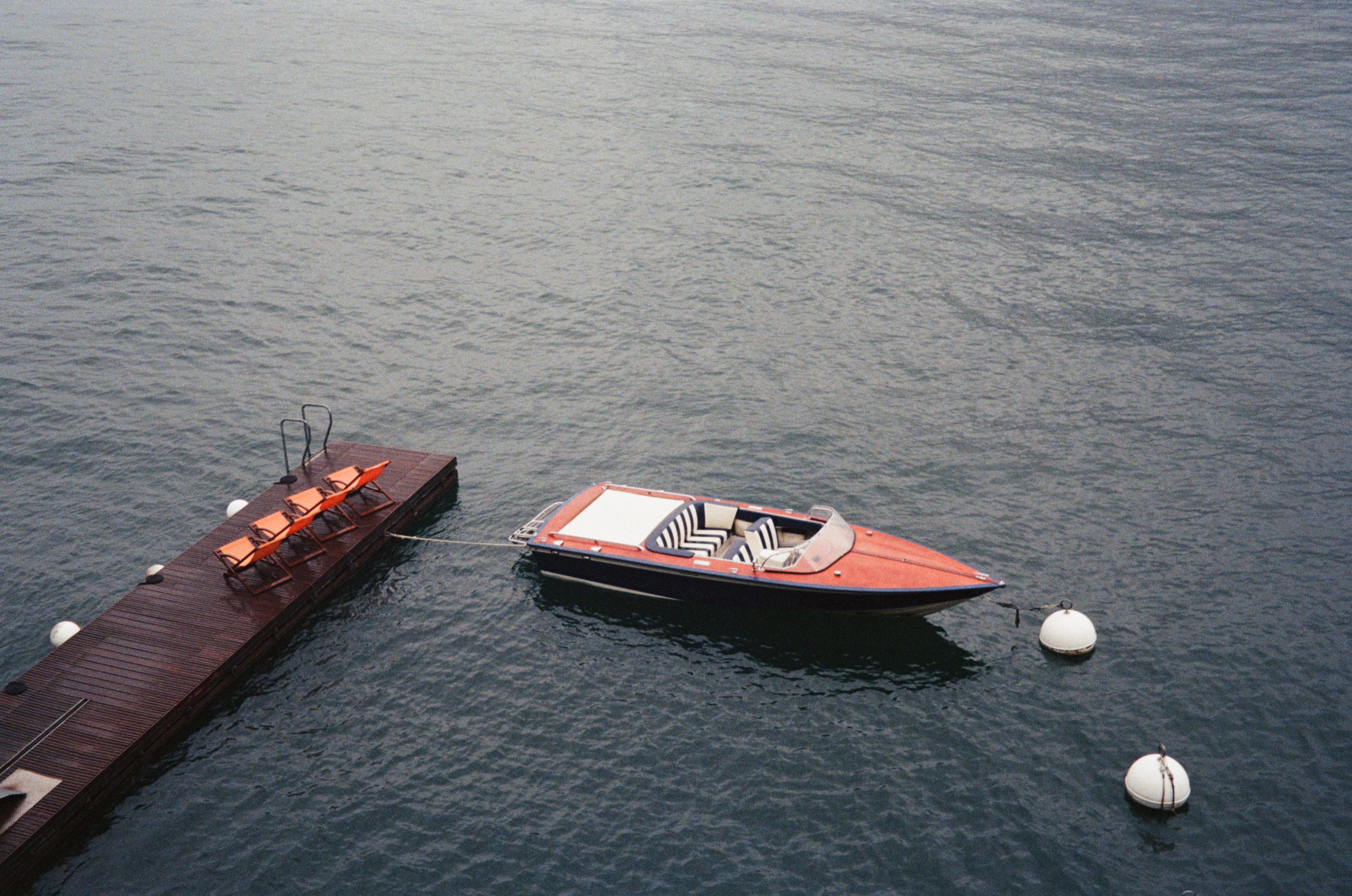 Boat tied to dock in lake Como.