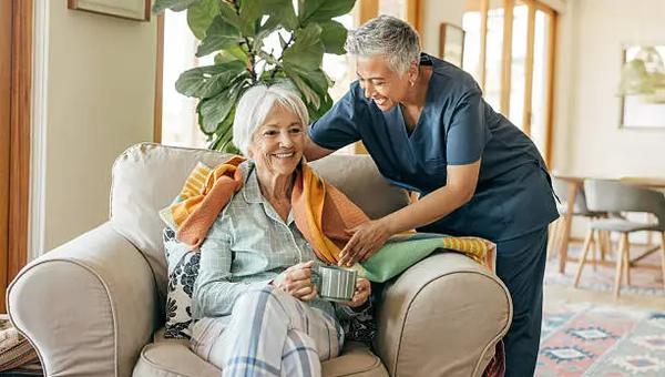 Professional caregiver assisting a senior resident in a modern elder care home in Chennai