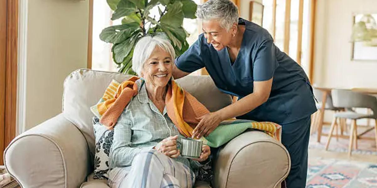 Professional caregiver assisting a senior resident in a modern elder care home in Chennai