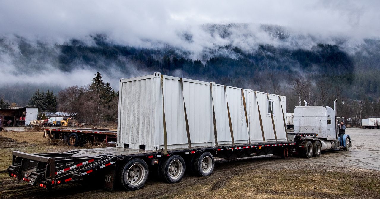 Three shipping containers being delivered