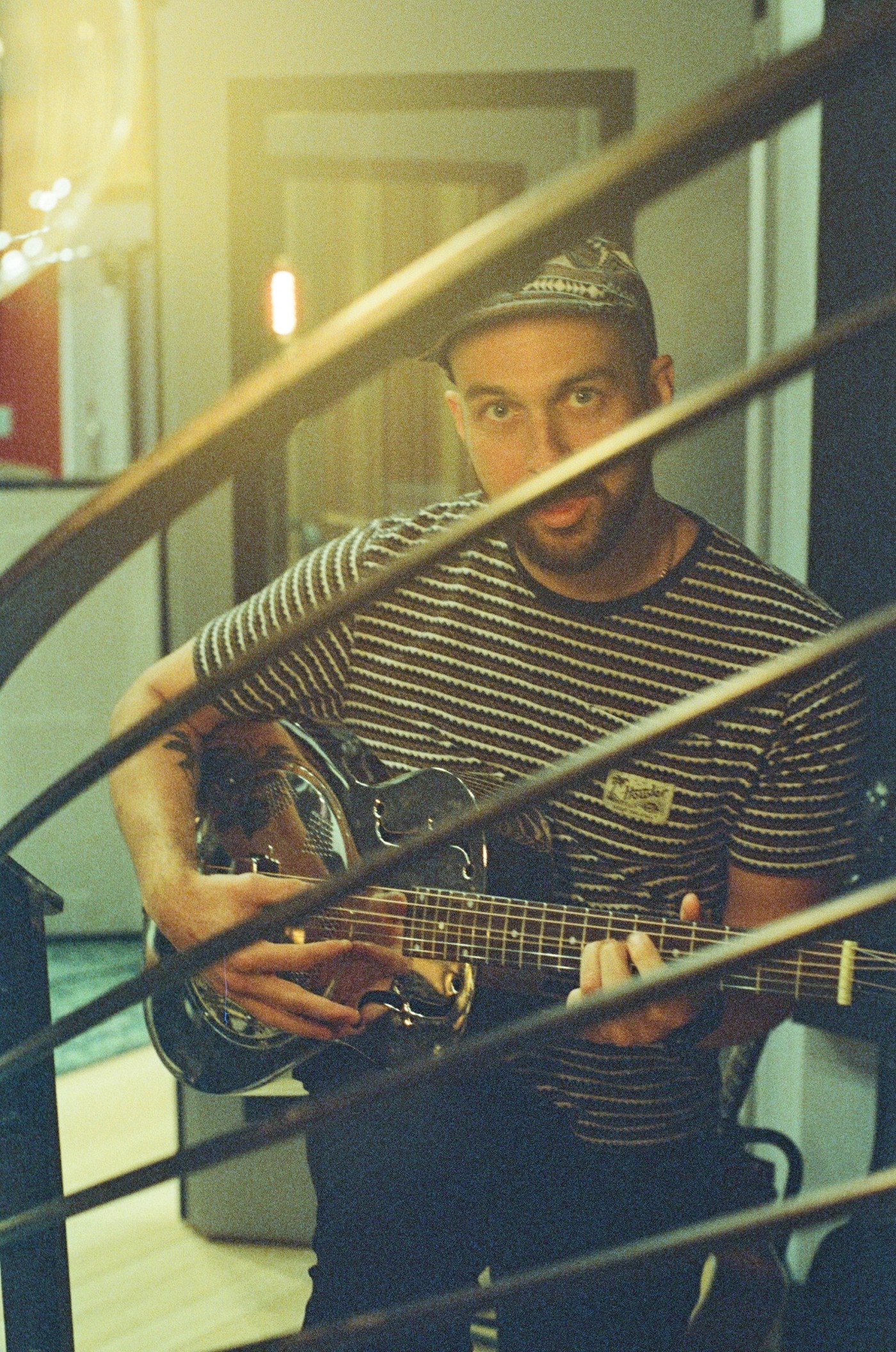 a man in a striped shirt is playing a guitar