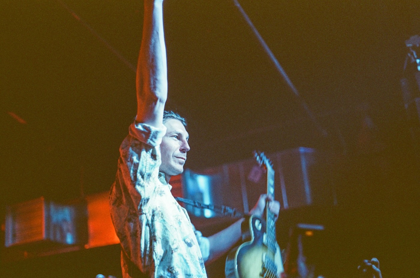 a man is playing a guitar and singing into a microphone on a stage .