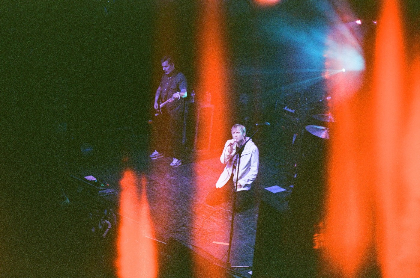 a man is singing into a microphone on a stage in front of a crowd .