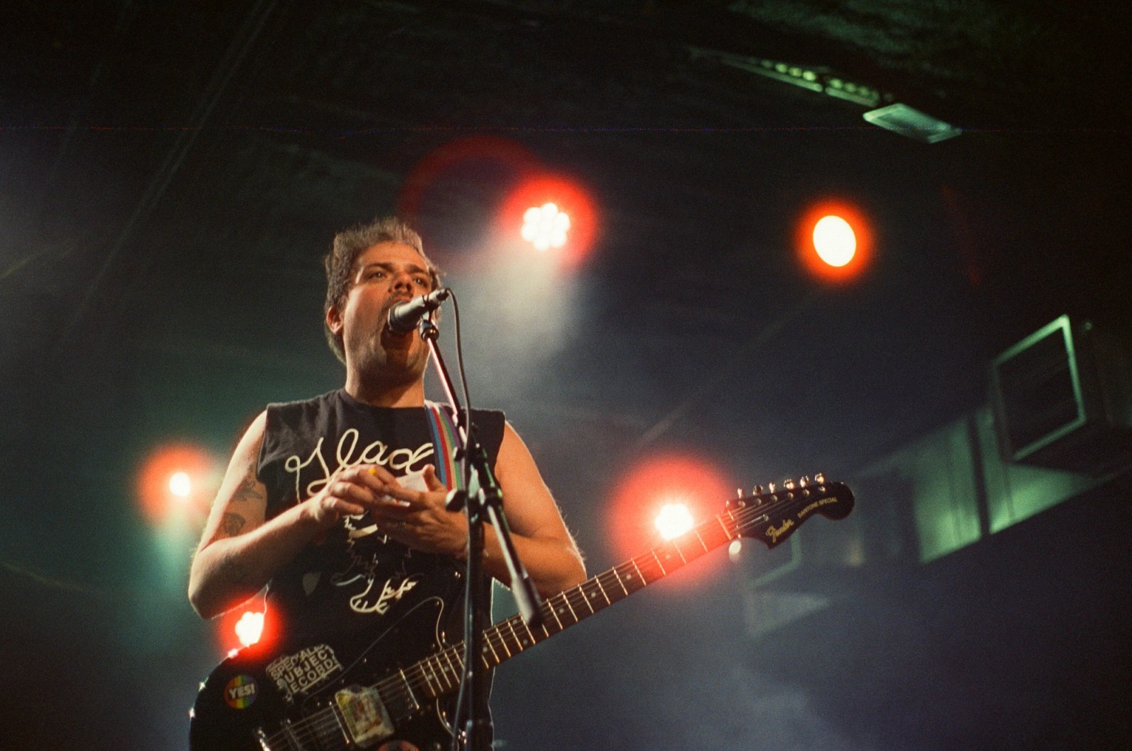 a man is singing into a microphone while playing a guitar on a stage .