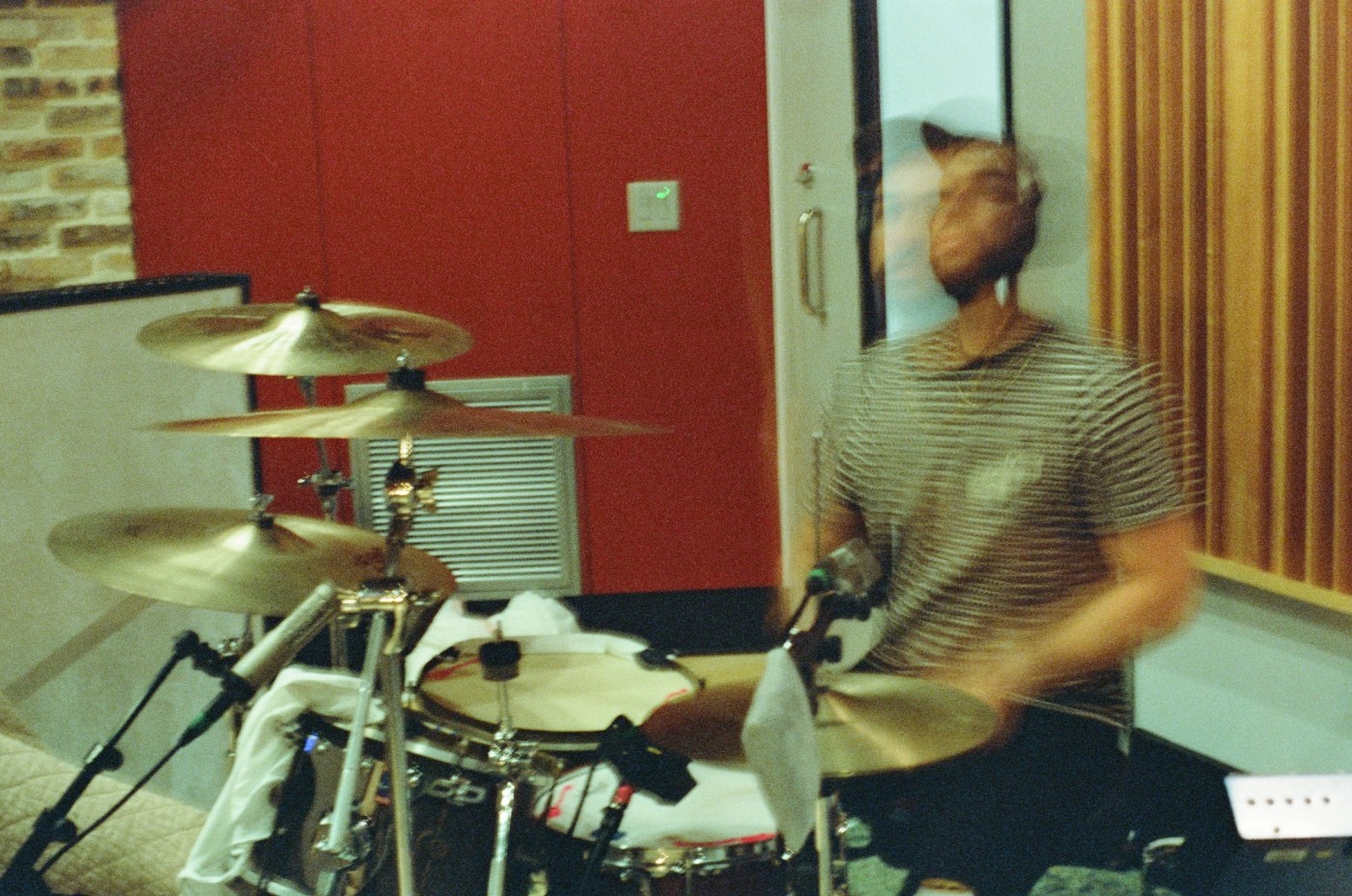 a man is playing drums in a recording studio .