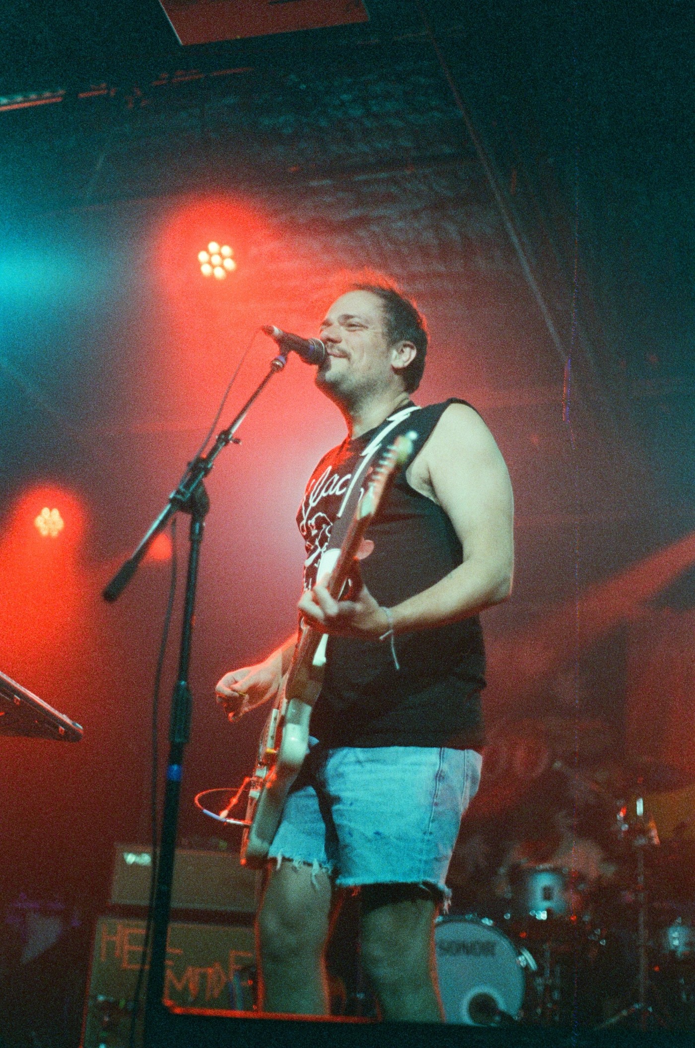 a man singing into a microphone while holding a guitar