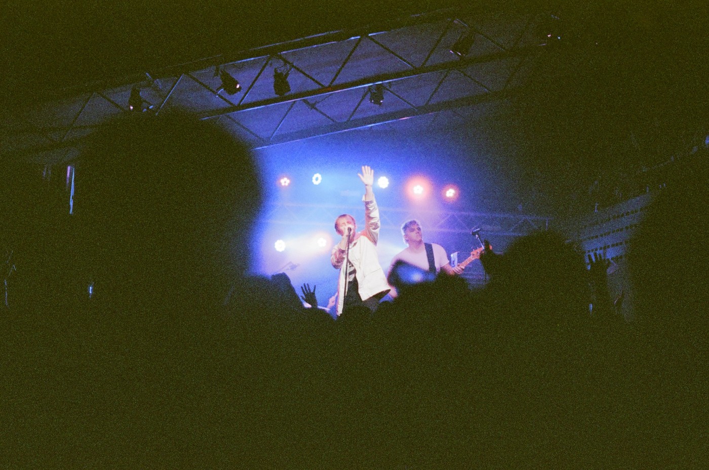 a man is singing into a microphone on a stage in front of a crowd .