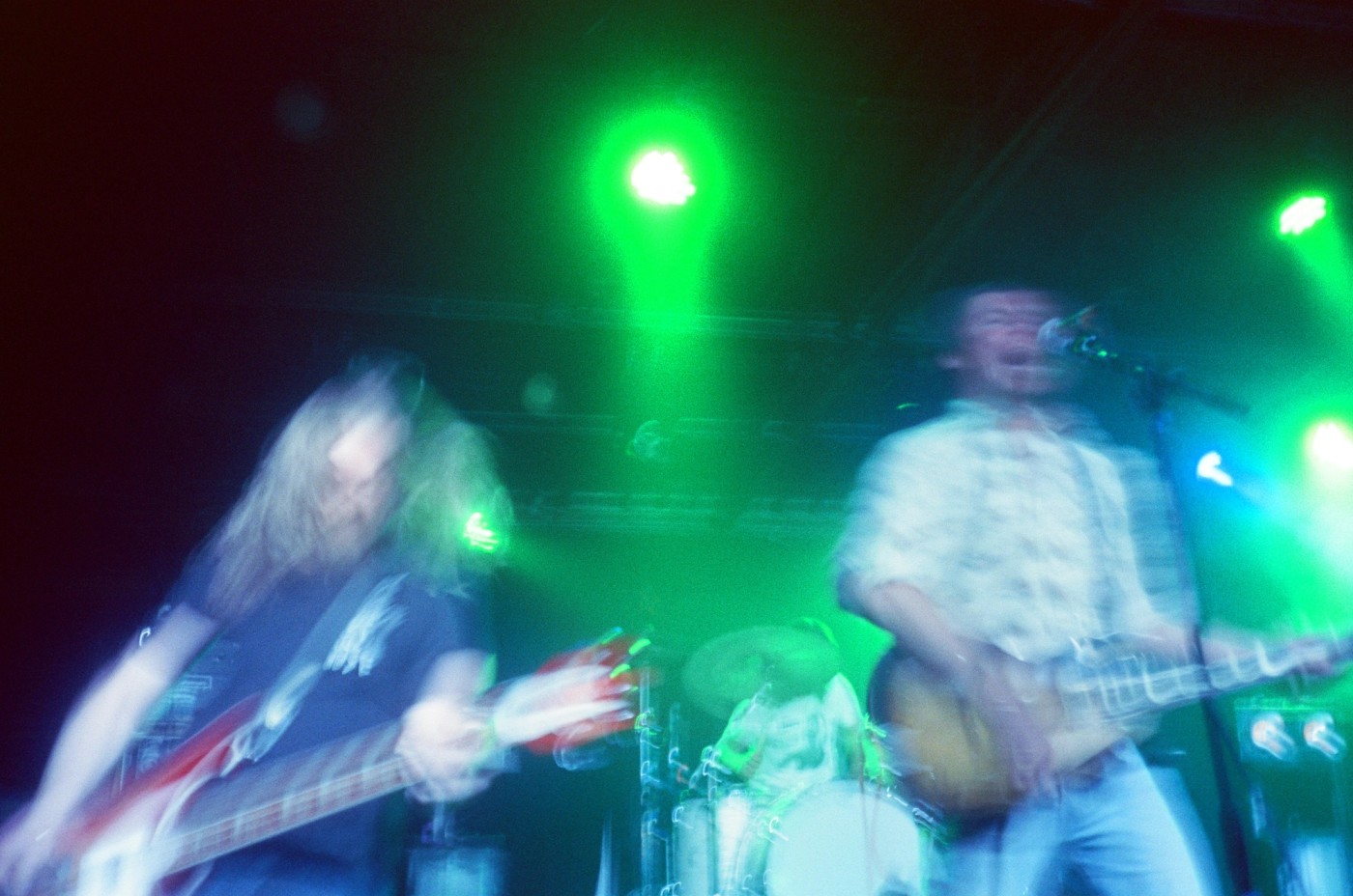 a blurry picture of two men playing guitars on a stage .