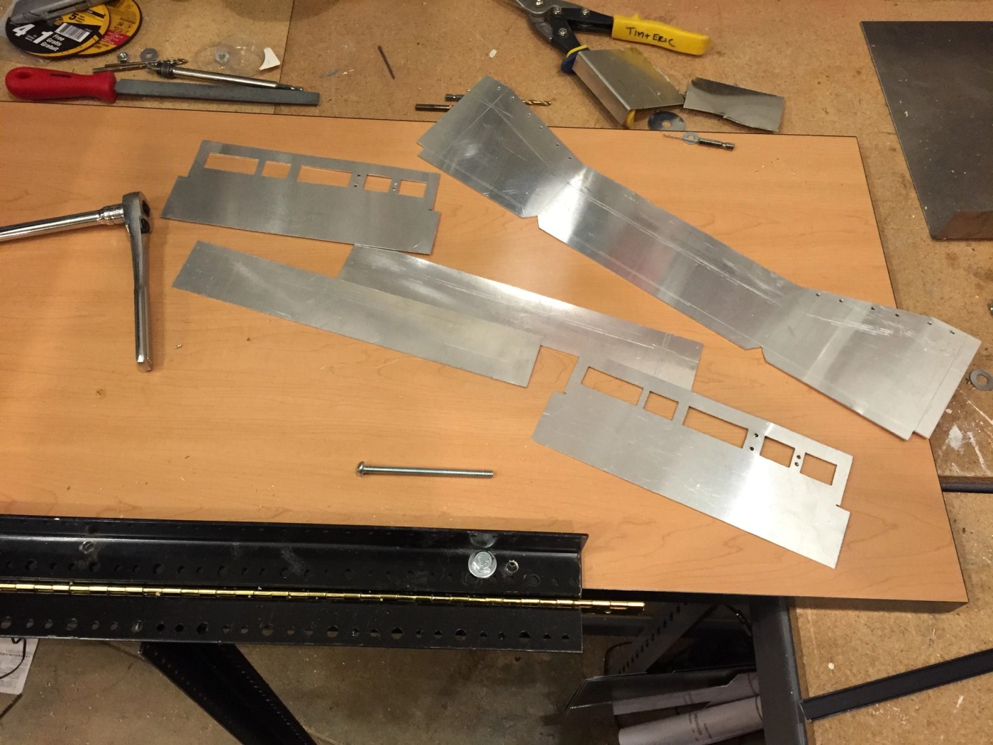 a wooden table with a bunch of metal pieces on it .