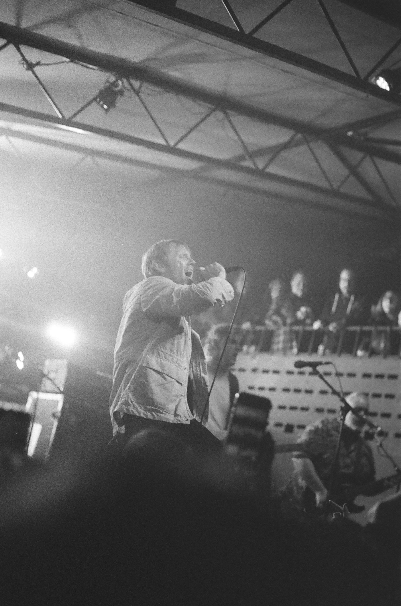 a black and white photo of a man singing into a microphone