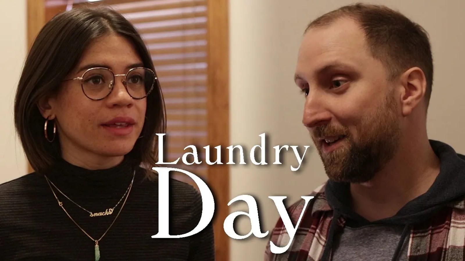 a man and a woman are standing next to each other in a laundry room .