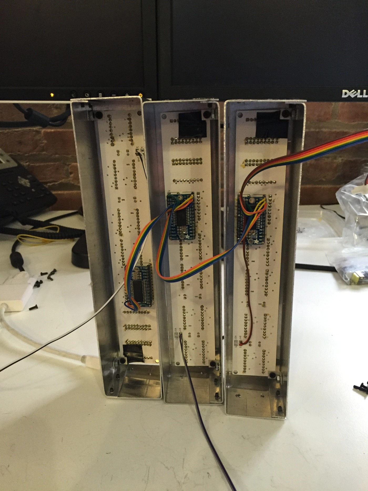 three dell monitors are sitting on a white table