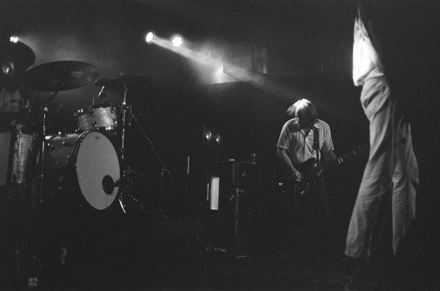 a black and white photo of two men playing instruments on a stage .