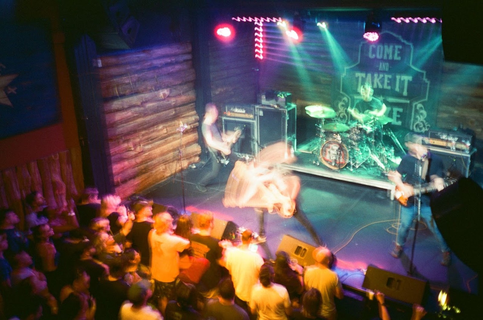 a group of people are sitting in a dark room watching a band perform on stage .