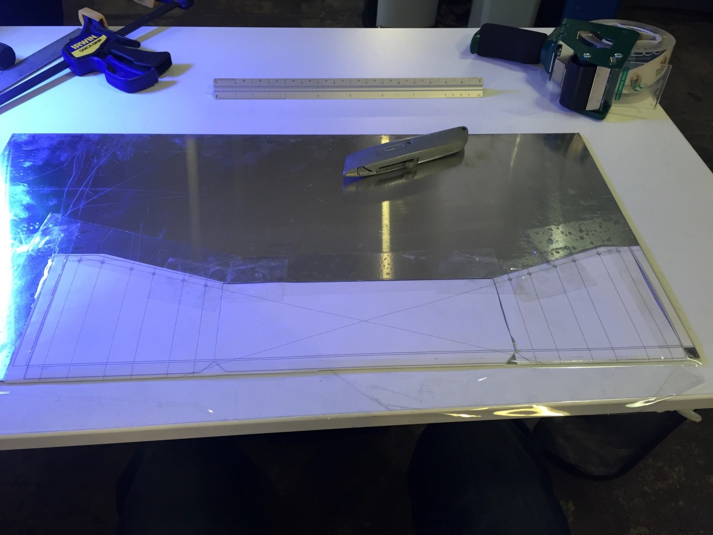 a person is cutting a piece of metal on a table .
