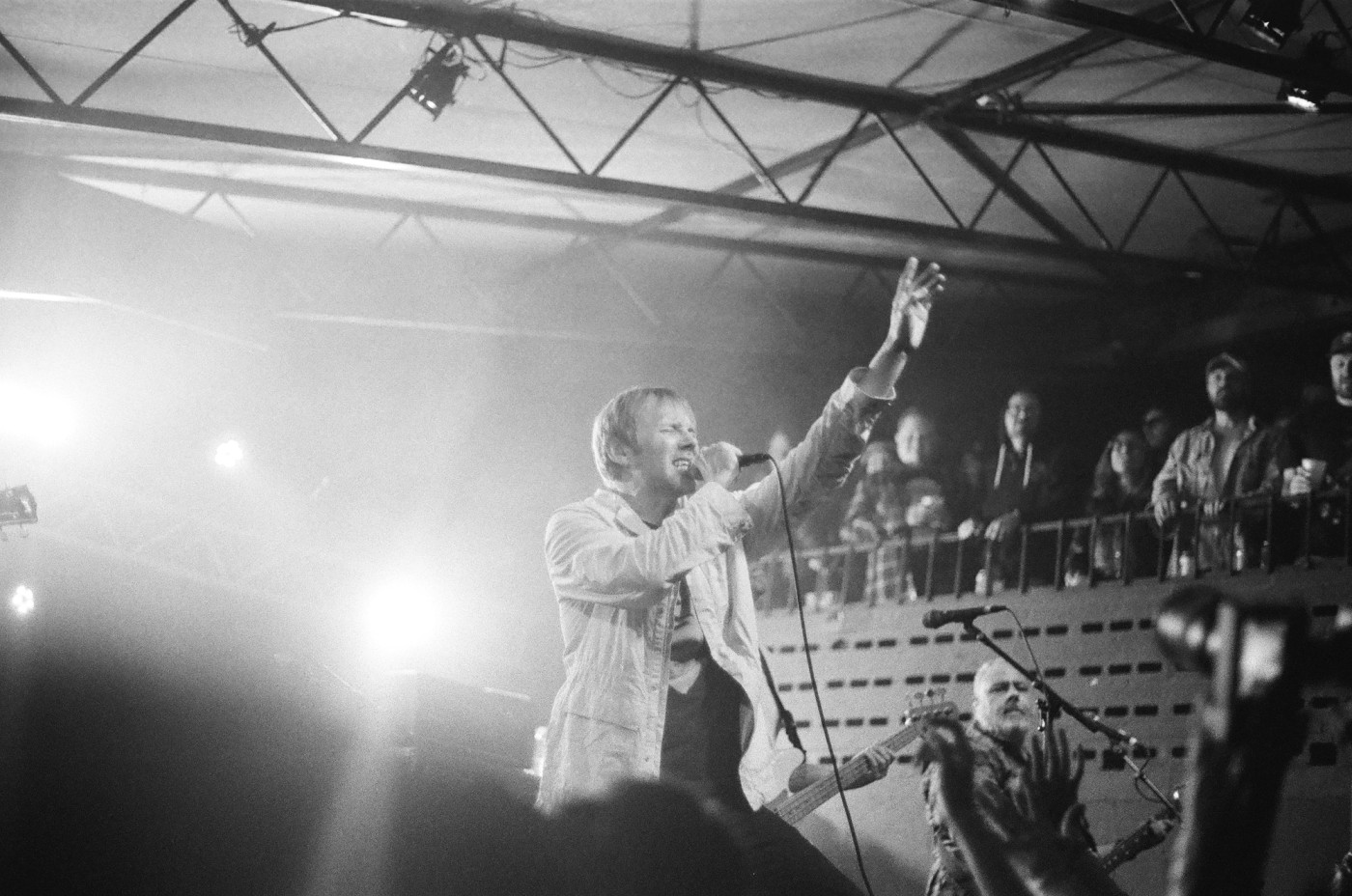 a man is singing into a microphone on a stage in front of a crowd .