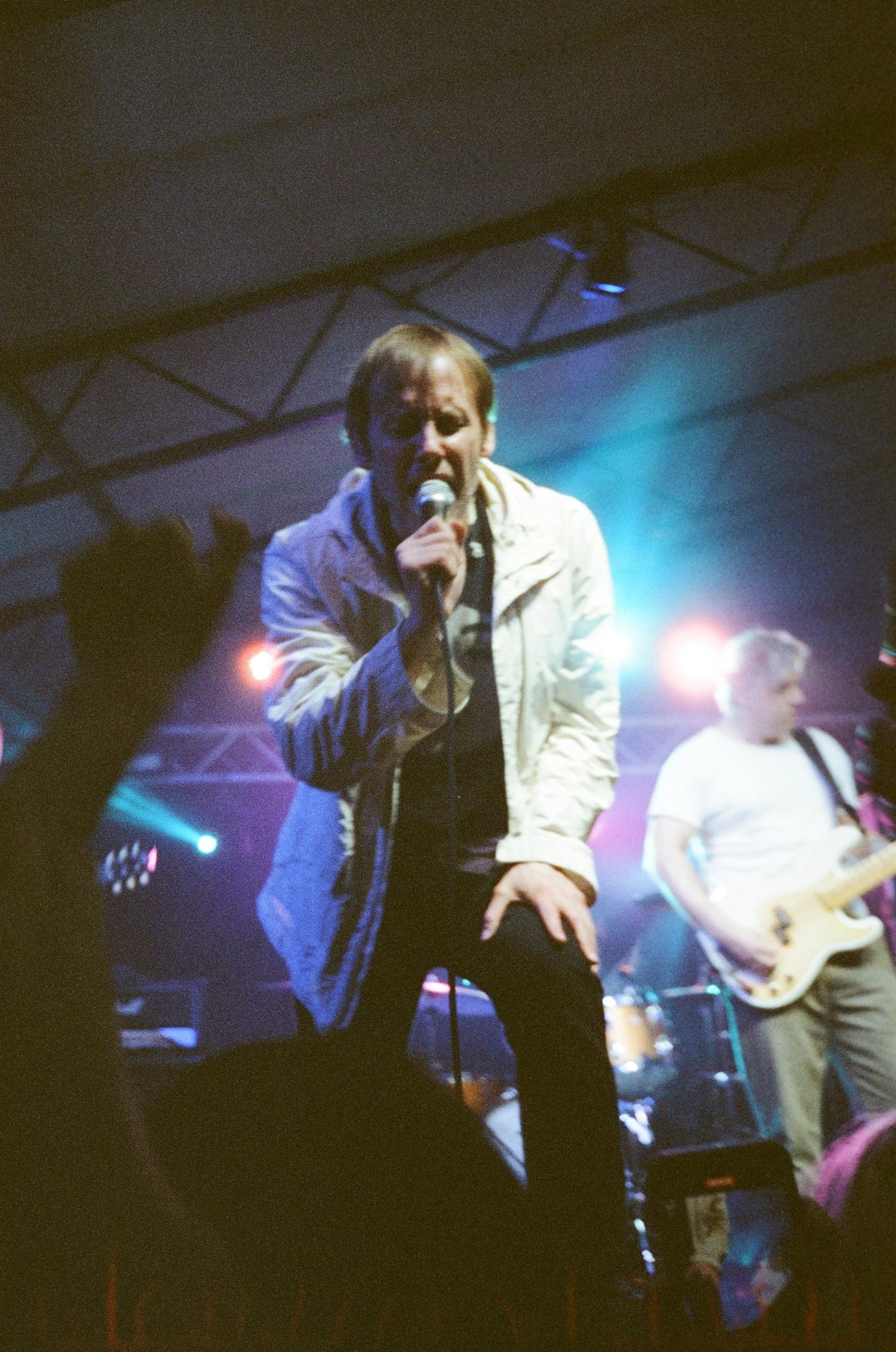 a man singing into a microphone in front of a crowd