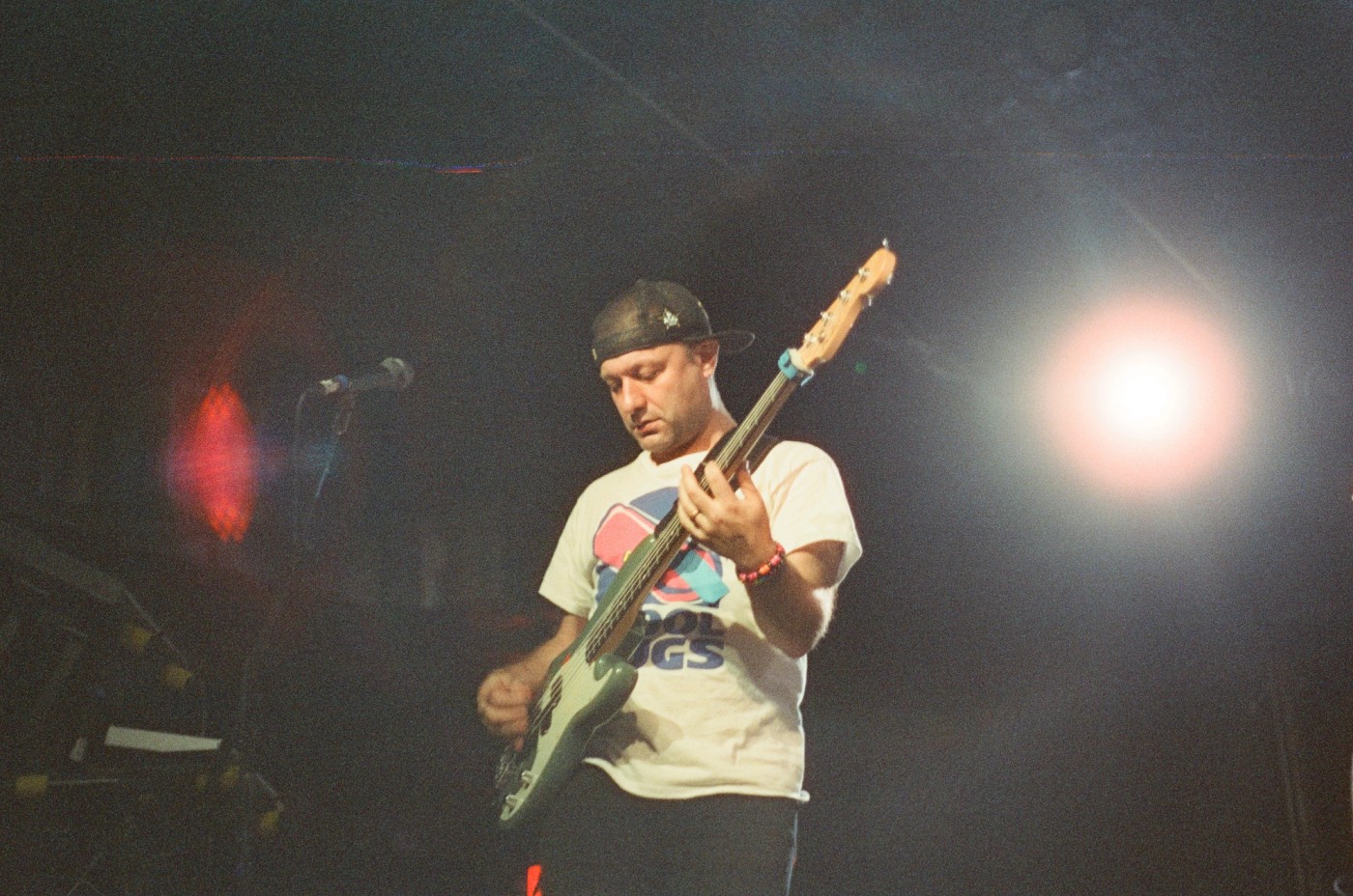 a man is playing a bass on stage in front of a microphone .