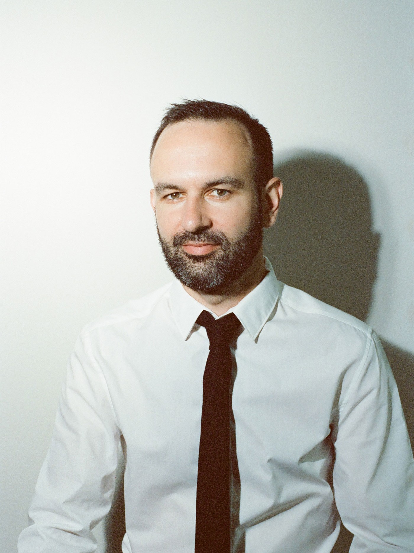 Matt Schaefer, a man with a beard wearing a white shirt and black tie