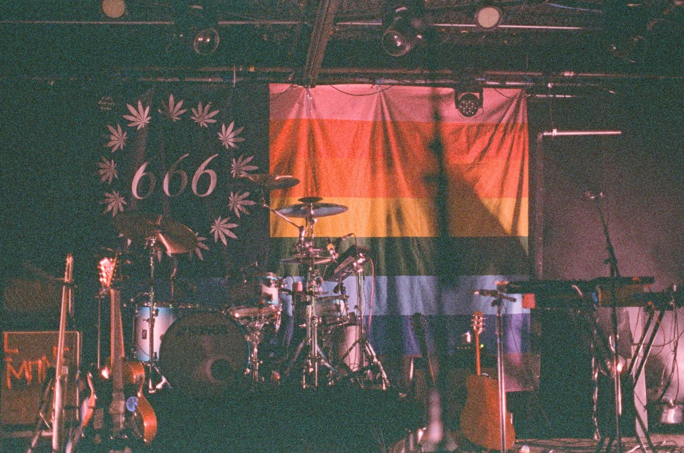 instruments on a stage with a rainbow flag in the background .