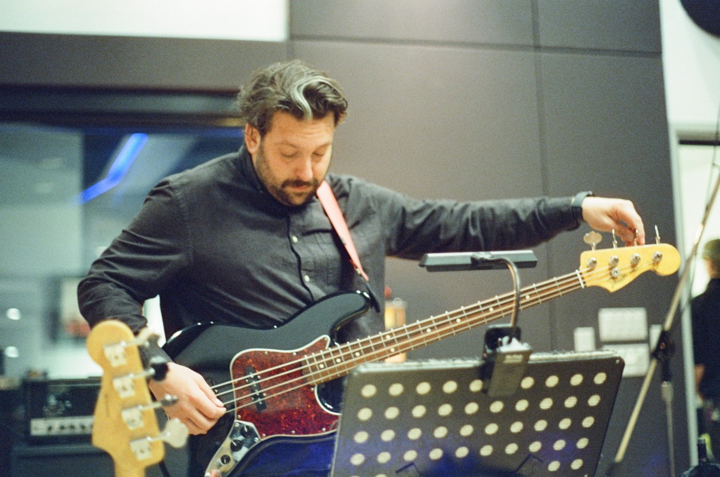 a man is playing a bass guitar in a room .