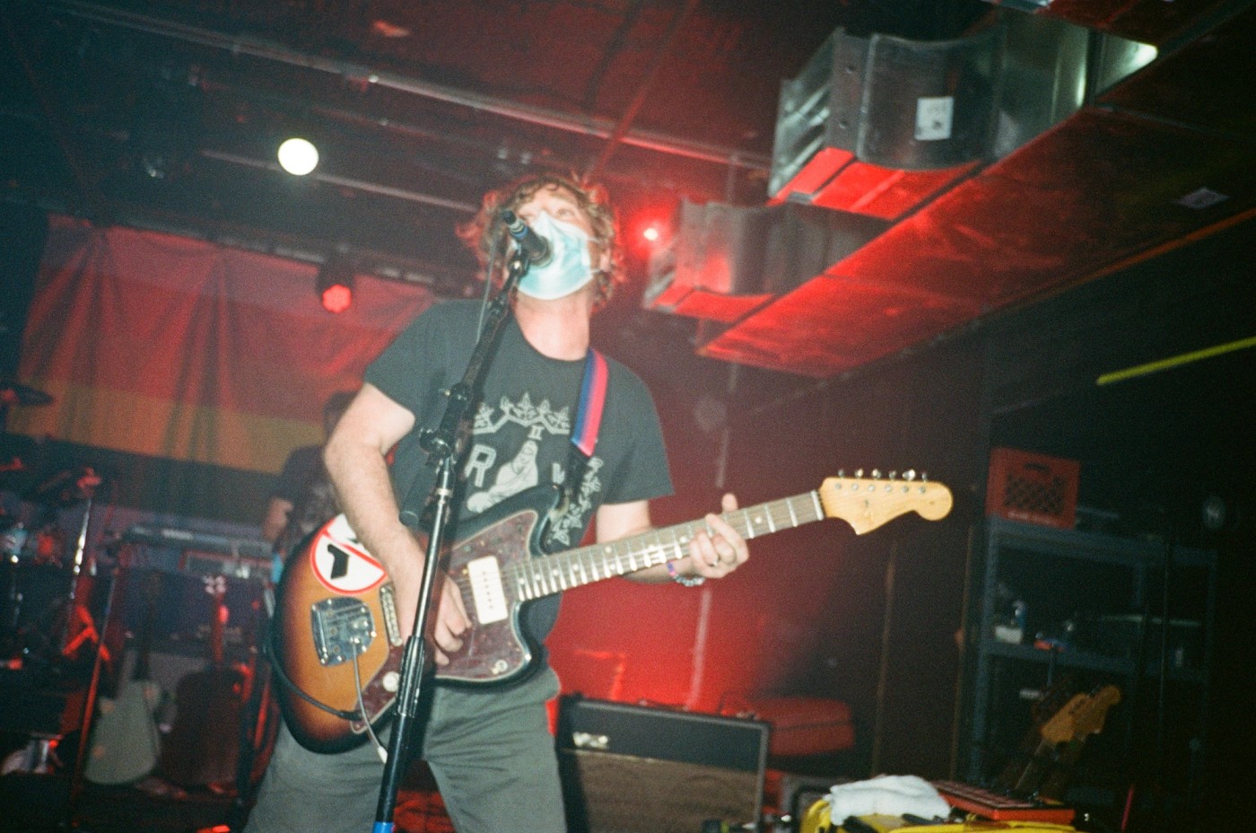 a man is playing a guitar and singing into a microphone on a stage .