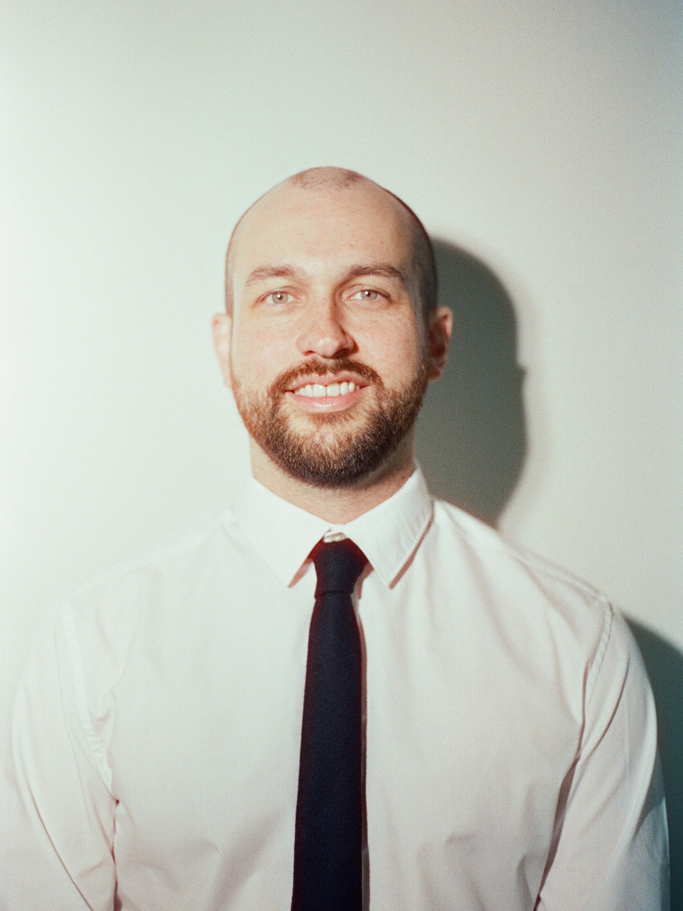 Jason Desiderio, a man with a beard wearing a white shirt and black tie