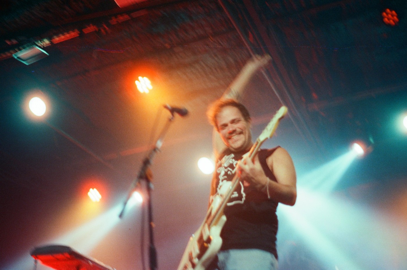 a man is playing a guitar on a stage in front of a microphone .