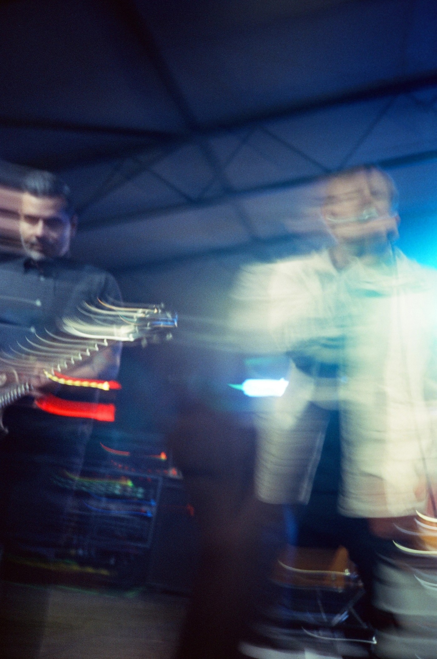 a blurry picture of a man playing a guitar in a dark room .